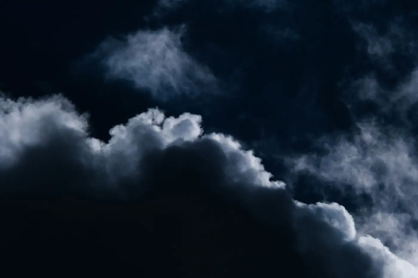 Dense dark storm clouds filling a night sky, obscuring the view above